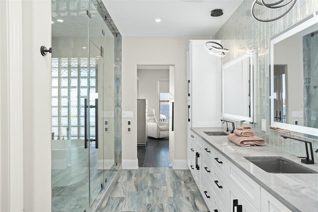 bathroom featuring vanity, wood-type flooring, a wealth of natural light, and a shower with shower door