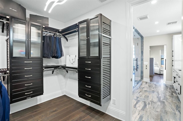 walk in closet with dark hardwood / wood-style flooring