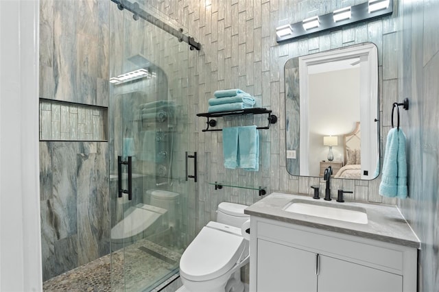 bathroom with a shower with door, tile walls, vanity, tasteful backsplash, and toilet