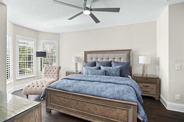 bedroom with ceiling fan, dark wood-type flooring, and a textured ceiling