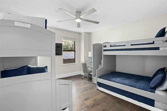 bedroom featuring dark wood-type flooring, ceiling fan, and a textured ceiling