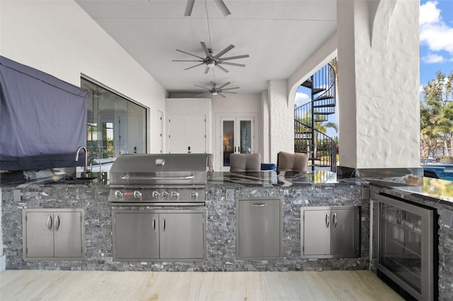 view of patio / terrace with an outdoor kitchen, sink, grilling area, ceiling fan, and beverage cooler