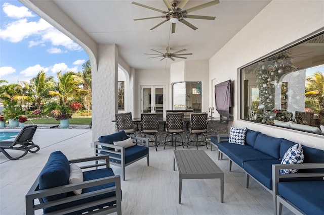 view of patio with exterior bar, outdoor lounge area, and ceiling fan