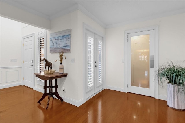 foyer entrance with french doors, crown molding, and hardwood / wood-style floors