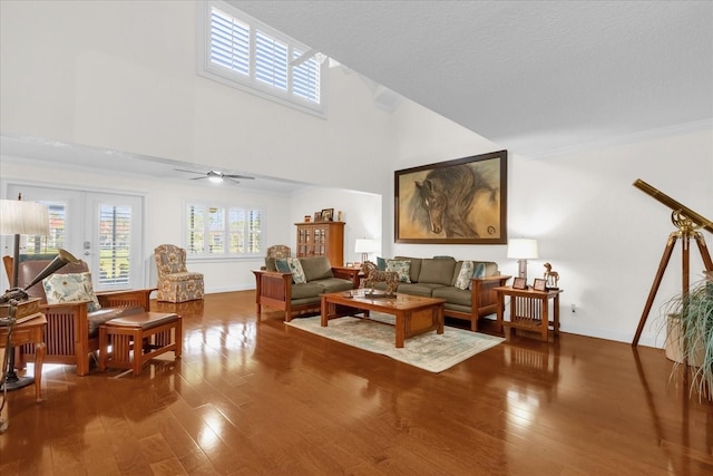 living room featuring french doors, a towering ceiling, hardwood / wood-style flooring, and ceiling fan