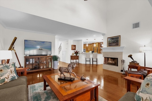 living room with light wood-type flooring and crown molding