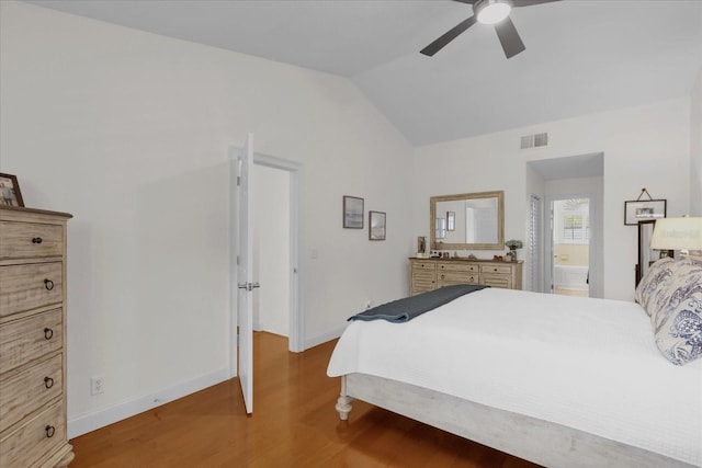 bedroom with ceiling fan, dark hardwood / wood-style floors, ensuite bathroom, and vaulted ceiling