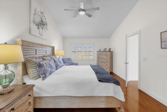 bedroom featuring ceiling fan, dark hardwood / wood-style floors, and vaulted ceiling