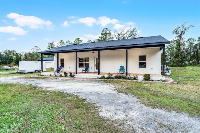 view of front of house featuring covered porch, ceiling fan, and a front yard