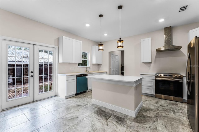 kitchen featuring wall chimney exhaust hood, a kitchen island, white cabinetry, and appliances with stainless steel finishes