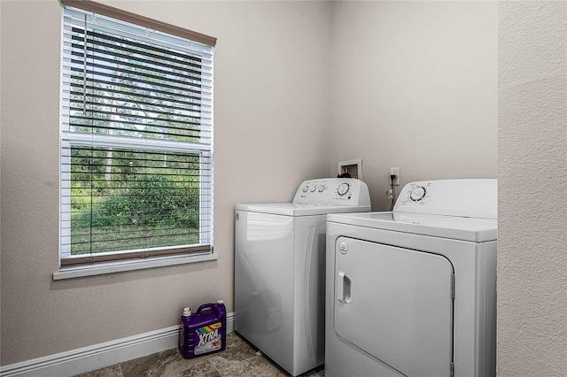 clothes washing area with a healthy amount of sunlight and washer and dryer