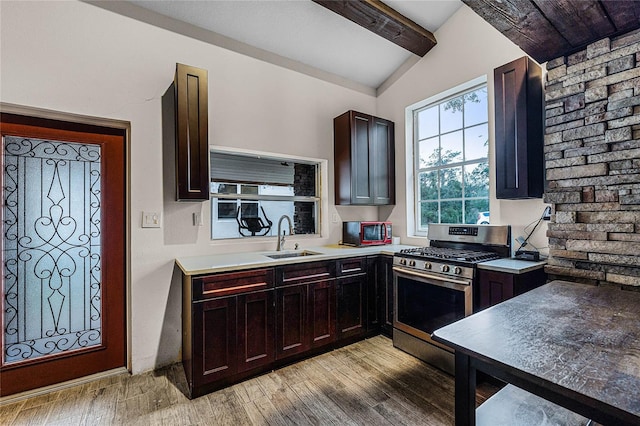 kitchen with lofted ceiling with beams, sink, light hardwood / wood-style flooring, stainless steel gas stove, and dark brown cabinets