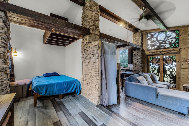 bedroom with beam ceiling, ceiling fan, and light wood-type flooring