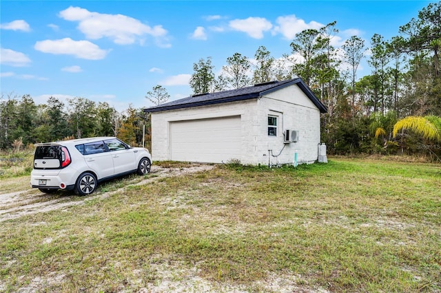 garage featuring an AC wall unit and a lawn