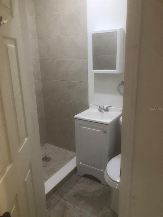 bathroom with vanity, toilet, and a shower