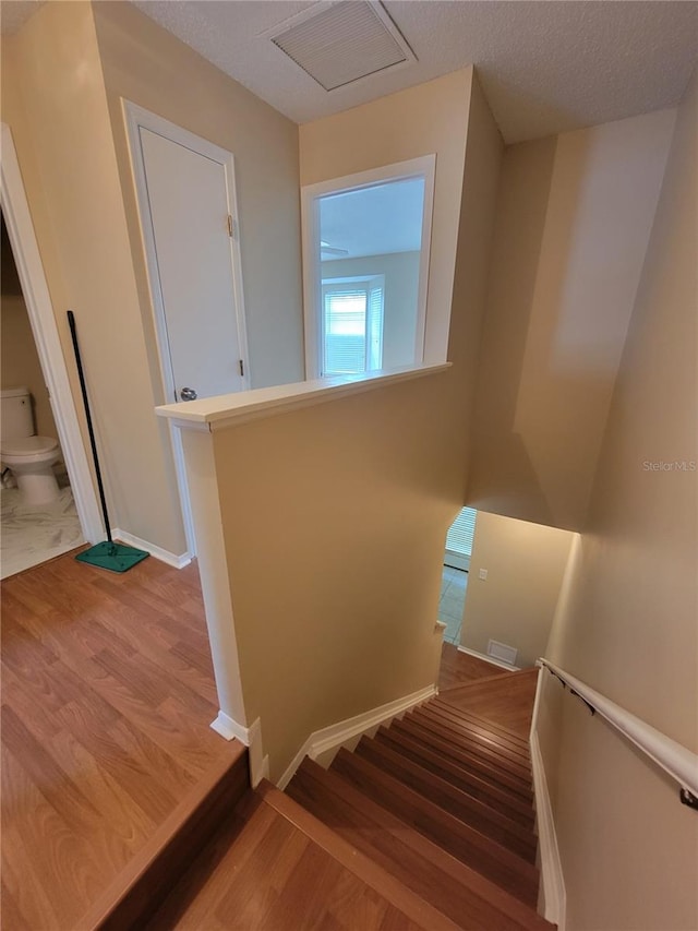 staircase with wood-type flooring