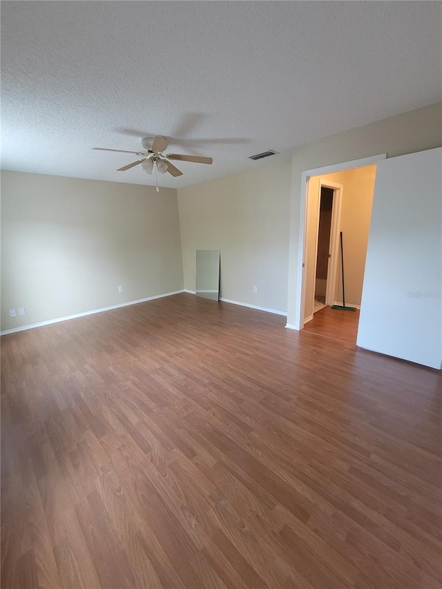 spare room with wood-type flooring, a textured ceiling, and ceiling fan