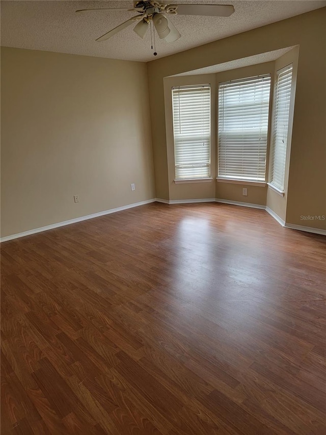 empty room with hardwood / wood-style floors, a textured ceiling, and ceiling fan