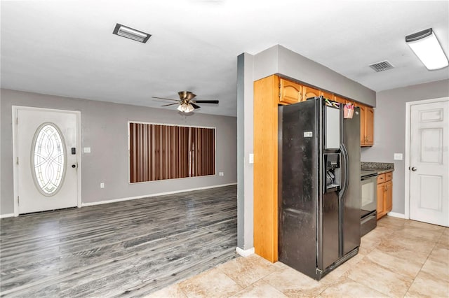 kitchen with ceiling fan, stainless steel electric range, and black fridge