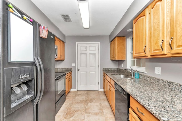 kitchen featuring sink, black appliances, and stone countertops