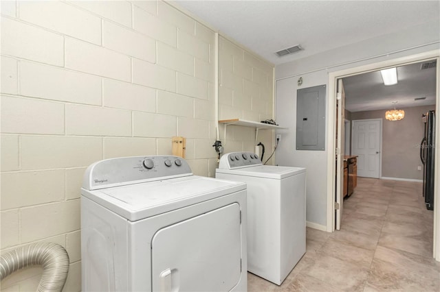 washroom featuring a notable chandelier, washing machine and dryer, and electric panel