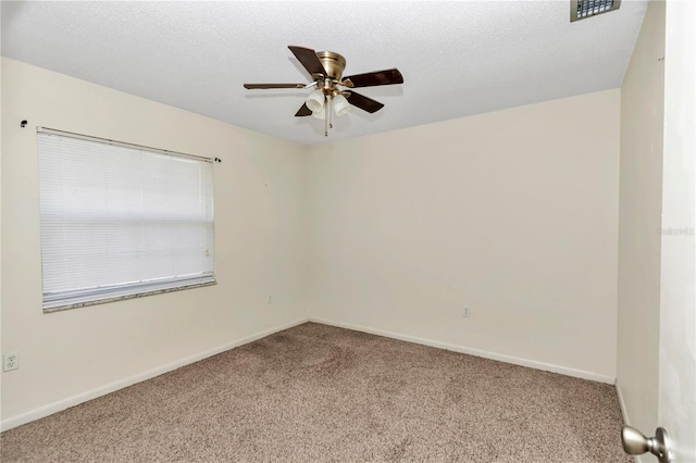 carpeted empty room with ceiling fan and a textured ceiling