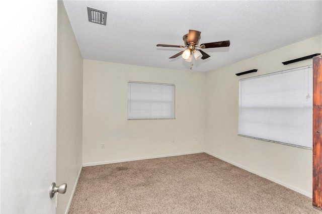 carpeted spare room with a textured ceiling and ceiling fan