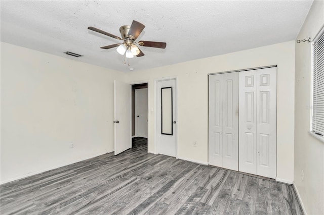 unfurnished bedroom with wood-type flooring, a textured ceiling, and ceiling fan