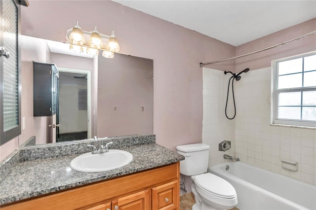 full bathroom featuring vanity, tiled shower / bath combo, and toilet