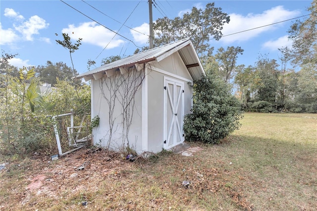 view of outbuilding featuring a lawn