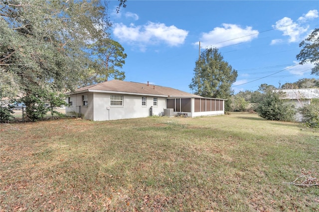 back of property with a sunroom and a yard