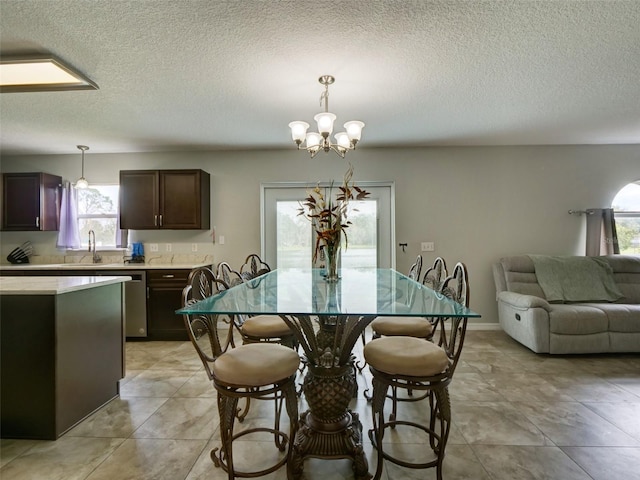 dining room with sink, a chandelier, and a textured ceiling