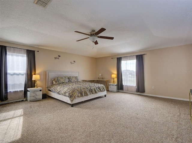 carpeted bedroom featuring ceiling fan and a textured ceiling