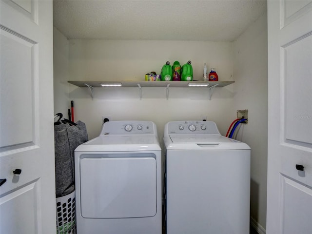 laundry area with a textured ceiling and washing machine and clothes dryer