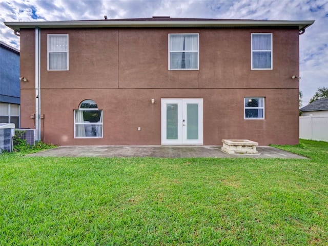 rear view of property featuring a yard, french doors, and a patio