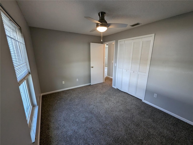 unfurnished bedroom with ceiling fan, carpet floors, a textured ceiling, and a closet