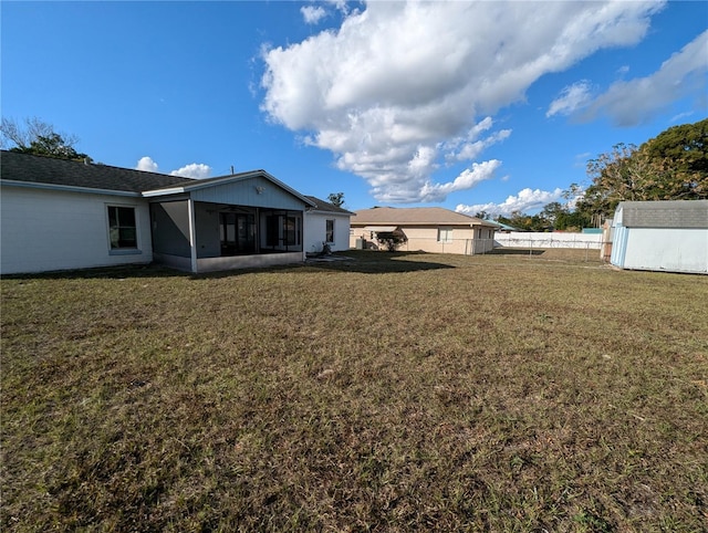 view of yard featuring a sunroom and a shed