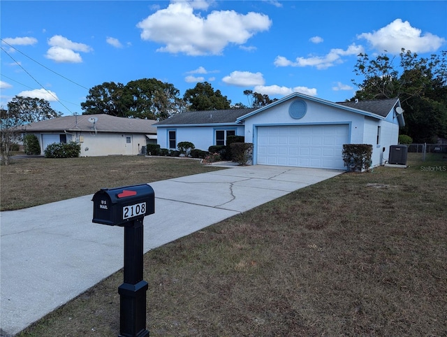 ranch-style house featuring a front lawn, central AC unit, and a garage