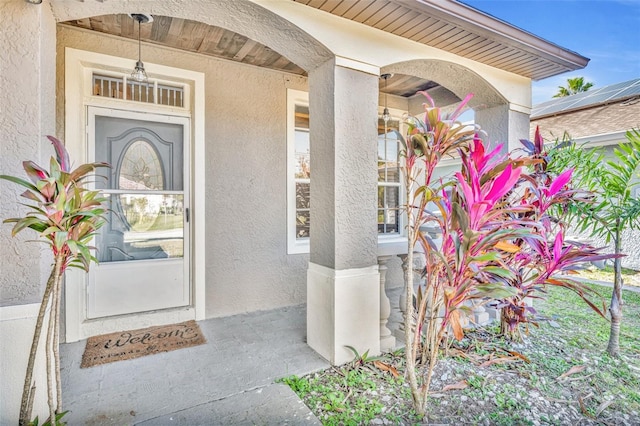 view of exterior entry featuring covered porch