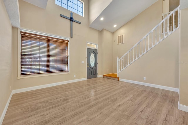 foyer entrance featuring a high ceiling and light hardwood / wood-style flooring