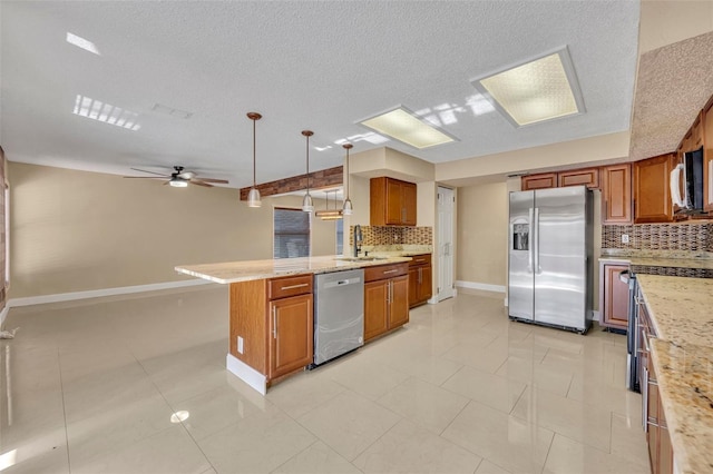 kitchen featuring appliances with stainless steel finishes, tasteful backsplash, ceiling fan, sink, and hanging light fixtures