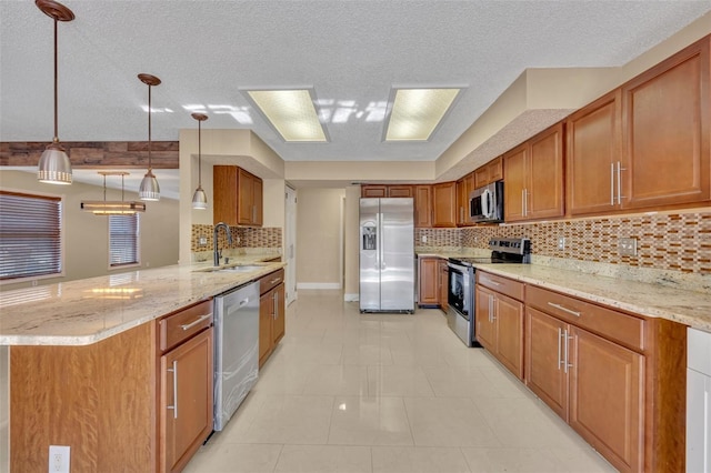 kitchen with sink, hanging light fixtures, appliances with stainless steel finishes, tasteful backsplash, and kitchen peninsula