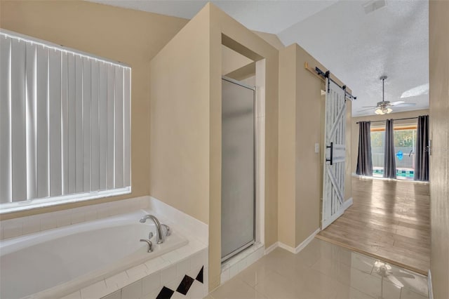 bathroom with lofted ceiling, tile patterned floors, ceiling fan, separate shower and tub, and a textured ceiling