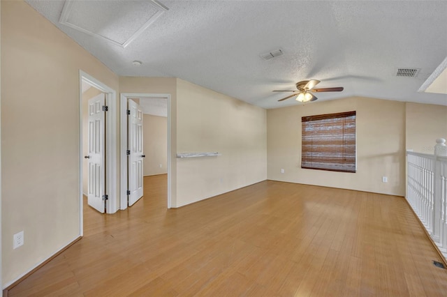 spare room with ceiling fan, a textured ceiling, and light hardwood / wood-style flooring