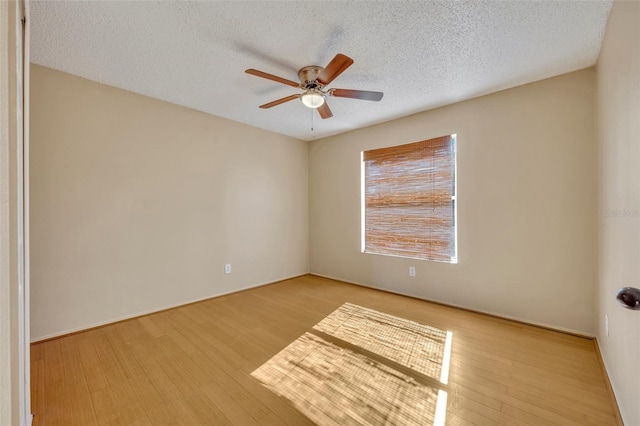 empty room featuring ceiling fan, light hardwood / wood-style flooring, and a textured ceiling