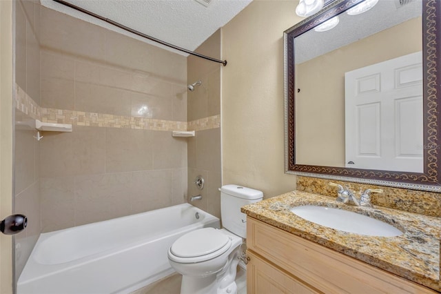 full bathroom featuring vanity, a textured ceiling, toilet, and tiled shower / bath