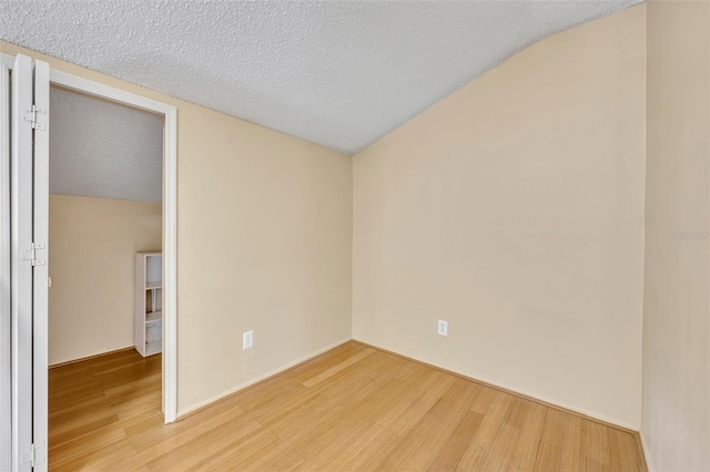 unfurnished room with a textured ceiling and hardwood / wood-style flooring