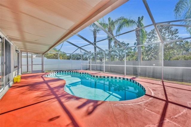 view of pool featuring glass enclosure and a patio area