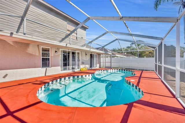 view of swimming pool featuring glass enclosure and a patio area