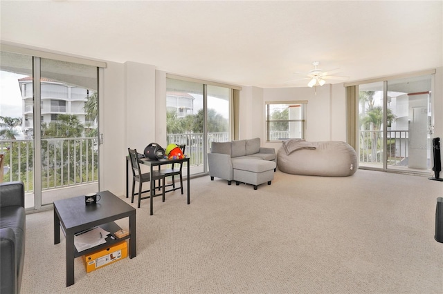 living room featuring ceiling fan, floor to ceiling windows, and light colored carpet